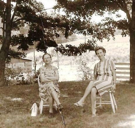 Vintage family photograph of two women seated outdoors beneath a tree